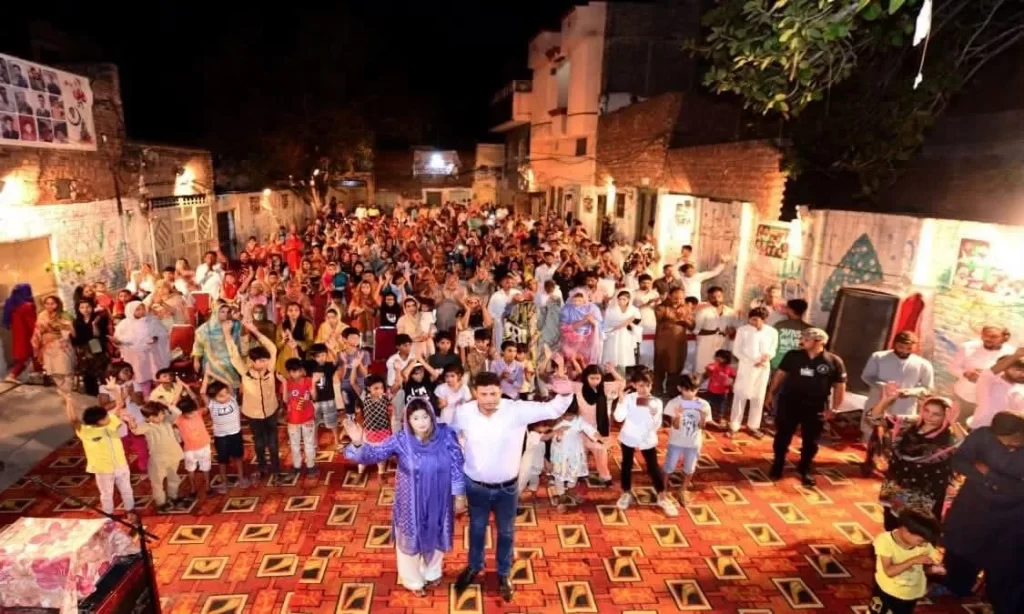Children and adults gather in a large, brightly decorated indoor event space.